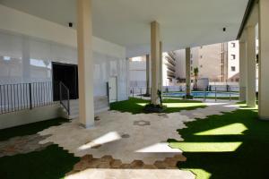 arium of a building with green grass and columns at Beautiful cozy seaside Apartment AQUARELLE in Calpe in Calpe