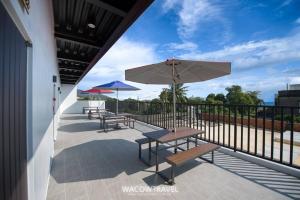 un patio con mesas y sombrillas en el balcón en Xiaoliuqiu 88 Homestay, en Xiaoliuqiu