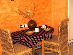 una mesa con dos sillas y un jarrón en ella en Dar El Amen Appartements en Mahdia