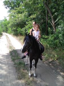 une femme et un enfant à cheval sur une route dans l'établissement Lazy Days, à Debrecen