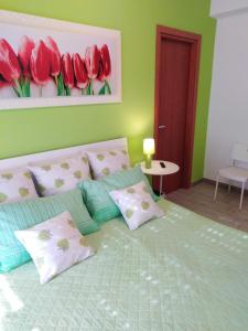 a bedroom with a bed with red flowers on the wall at Alloggio breve Anthea in Bari