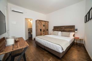 1 dormitorio con cama y mesa de madera en Piccolo Feudo en Sanluri