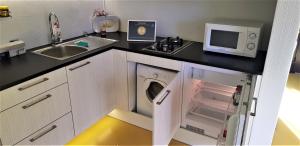 a small kitchen with a microwave and a washer and dryer at Guest House Bermuuda Apartment in Paide