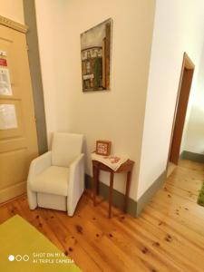 a living room with a chair and a table at Alojamento Local F&B in Guimarães