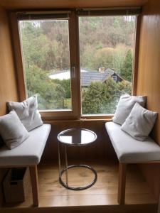 Habitación con 2 sillas, mesa y ventana en Villa Waldesruh en Siegburg