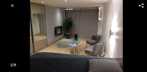 a bedroom with a bed and a chair and a table at Le Menhir Jacuzzi Lit 200x200 in Le Cendre