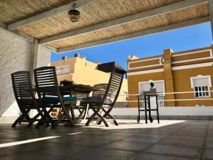 マラガにあるMalaga Beach House, 2 city bikes, 2 children's bikes, WiFi, BIG terrace, BBQ, Family, Childfriendlyのパティオ(テーブル、椅子付)