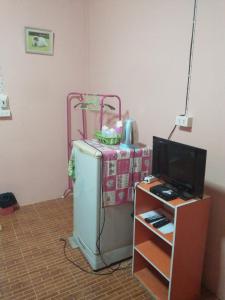 a room with an old refrigerator and a television at ห้องพัก โฮมทรัพย์ in Ban Thung Pla Kat