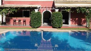 a swimming pool in front of a house at Villa De Loulia in Peroulades