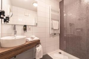 a bathroom with a sink, toilet and bathtub at Altstadthotel Guesthouse Die Galerie in Ingolstadt