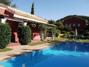 a swimming pool in front of a house at Villa De Loulia in Peroulades