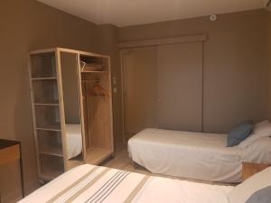 a bedroom with two beds and a closet at Logis Hôtel Terre de Loire in Belleville-sur-Loire