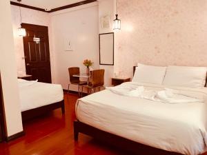 ダバオシティにあるTINHAT Halal حلال Certified Boutique Hotel And Restaurantのベッド2台とテーブルがあるホテルの部屋
