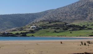 a hill with houses on it next to a body of water at Kalados -Beachfront Studios & Restaurant - in Kalando