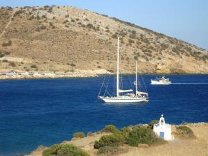 two boats floating in the water near a mountain at Kalados -Beachfront Studios & Restaurant - in Kalando