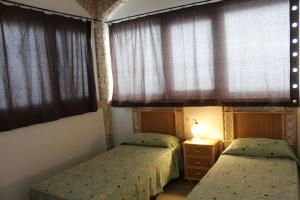 two beds in a small room with windows at Villa Simonetta in Alliste