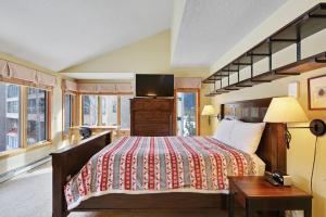 a bedroom with a bed with a tv on it at Montezuma Condominiums in Keystone