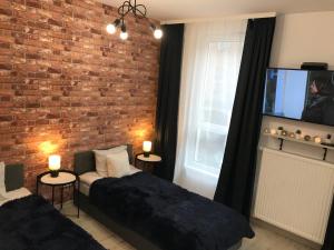 - une chambre avec un lit et un mur en briques dans l'établissement Apartamenty Brzeska 10, à Varsovie