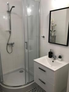 Un baño blanco con ducha y lavabo. en Apartamenty Brzeska 10, en Varsovia 58 fotos más