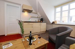 a kitchen with a table with a bottle of wine at Aparthotel Markt Fuffzehn in Stralsund
