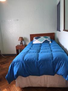a blue bed with a blue comforter in a bedroom at Viña Colores in Viña del Mar