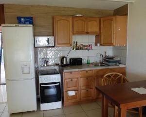 a kitchen with a white refrigerator and wooden cabinets at Studio Marigot, Vue Panoramique in Saint Martin