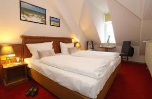 a bedroom with a large white bed in a room at Aparthotel Markt Fuffzehn in Stralsund