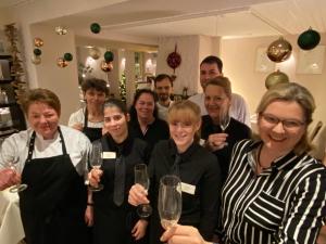 un grupo de personas posando para una foto con copas de vino en Hotel Ebnet, en Mutterstadt