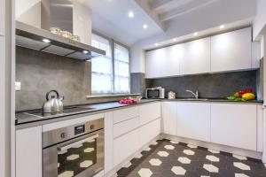 a kitchen with white cabinets and a checkered floor at Palazzo Chigi Zondadari in Siena