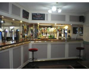 bar z dwoma stołkami barowymi przed nim w obiekcie Crown Hotel w mieście Pwllheli
