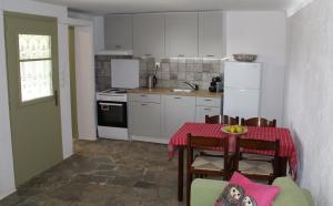 een keuken met een tafel en een keuken met witte apparatuur bij Lemon Garden house near the sea in Lagonissi