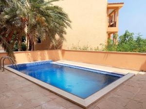 a swimming pool in front of a house at Dibba, Villa 61 - Mina Al Fajer, Dibba Al Fujairah in Rūl Ḑadnā