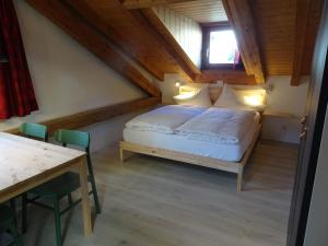 B&B Chasa Arfusch في Ardez: غرفة نوم بسرير وطاولة في غرفة