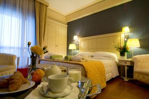 una camera d'albergo con letto e tavolo con cibo di Grand Hotel Terme & SPA a Chianciano Terme