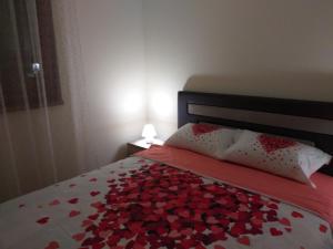 een bed met een bos van rode harten erop bij Aphrodite Apartment in Podgorica