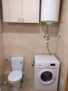 a bathroom with a toilet and a washing machine at Aphrodite Apartment in Podgorica +13 photos