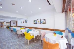 a dining room with white tables and colorful chairs at Infinity City Hotel in Fethiye +37 photos