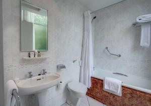 a bathroom with a sink, toilet and bathtub at Edinburgh Grosvenor Hotel in Edinburgh