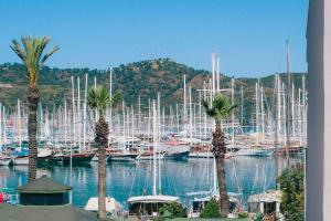 un montón de barcos atracados en un puerto deportivo con palmeras en Infinity City Hotel, en Fethiye