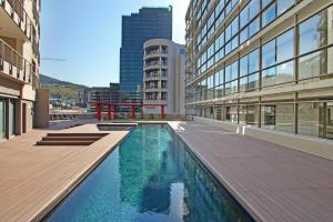 un edificio con piscina en medio de un edificio en Full Power, long stay rates, walk to V&A Waterfront, fibre WIFI, gym & pool, en Ciudad del Cabo