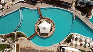 an overhead view of a swimming pool with an umbrella at Mitsis Selection Blue Domes in Kardamaina