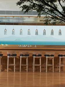 a row of stools in front of a bar at Mitsis Selection Blue Domes in Kardamaina