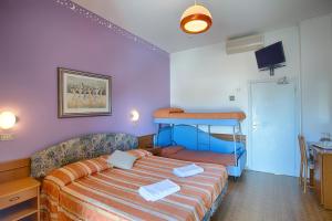 een slaapkamer met een bed en een stapelbed bij Hotel Meritime in Bellaria-Igea Marina
