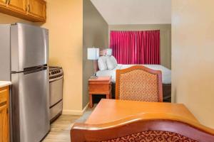 a kitchen with a refrigerator and a table in a room at Econo Lodge Inn & Suites Durango in Durango