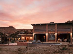 Eco Karoo Mountain Lodge في Luckhoff: منزل في الصحراء وقت الغروب