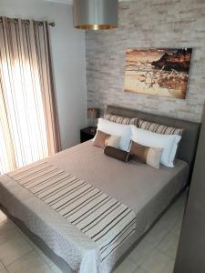 una camera da letto con un grande letto con cuscini di Euphoria Skiathos a Città di Skiathos