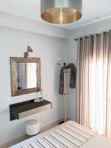 a bedroom with a bed and a mirror on the wall at Euphoria Skiathos in Skiathos Town