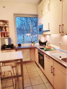 a kitchen with white cabinets and a table and a window at schönes Privatzimmer in Hamburg Winterhude in Hamburg