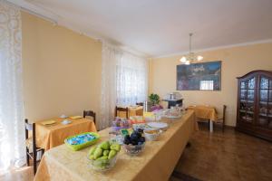 a room with a long table with bowls of fruit on it at La Rosa dei Venti B&B in Chia