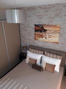um quarto com uma cama com uma parede de tijolos em Euphoria Skiathos em Skiathos